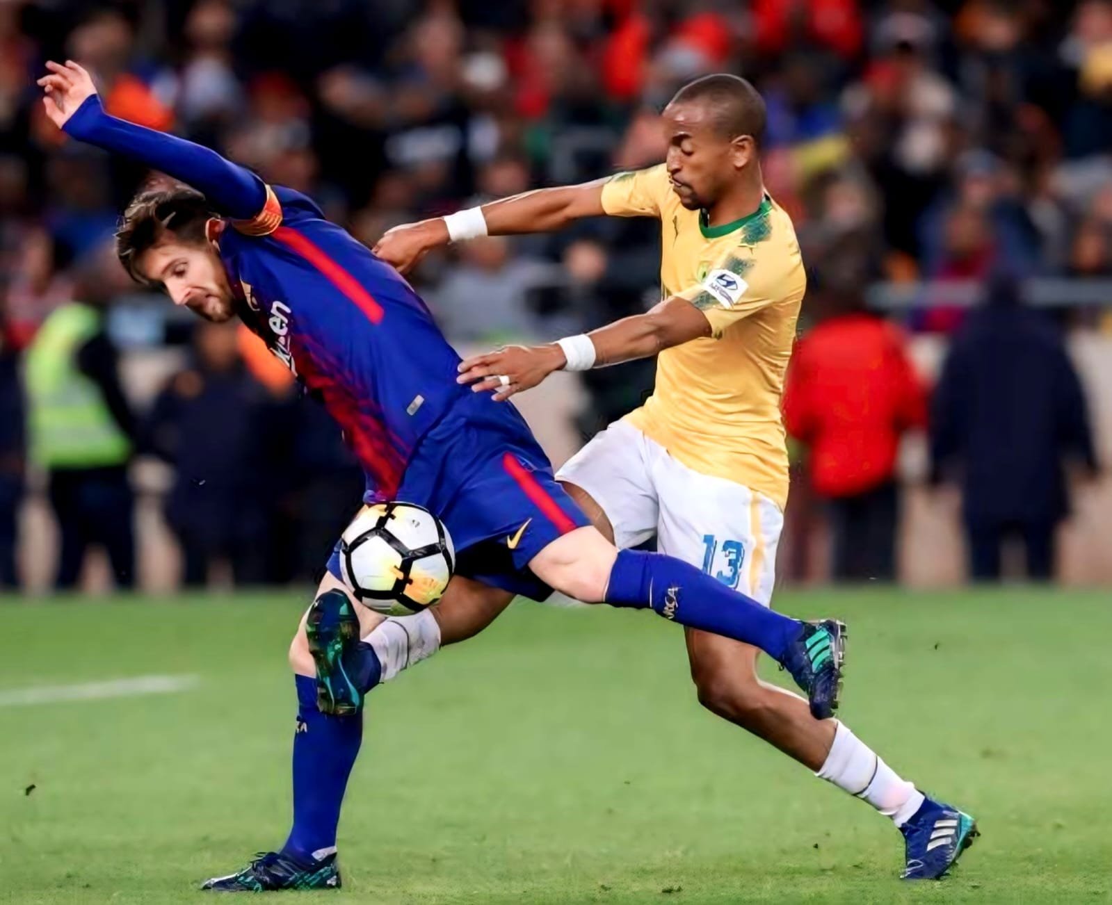 Tiyani Mabunda challenging Lionel Messi for the ball against FC Barcelona