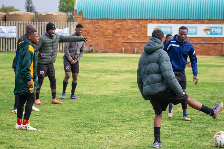A coach passes the ball during a training session